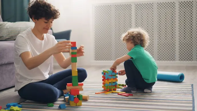 a man and a child playing with blocks on the floor