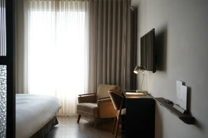 a hotel room with a bed, chair and television